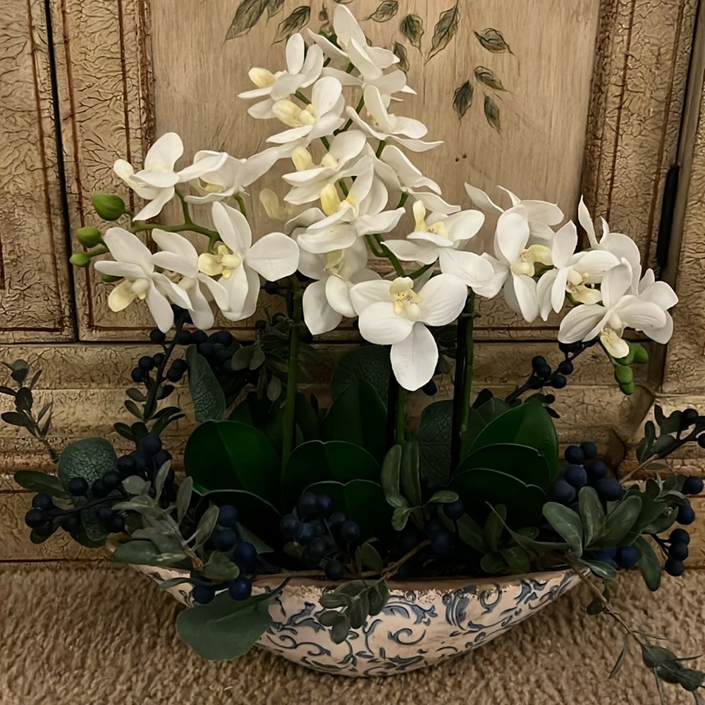 Handmade magnolia and berries in a boat shape vintage vase.